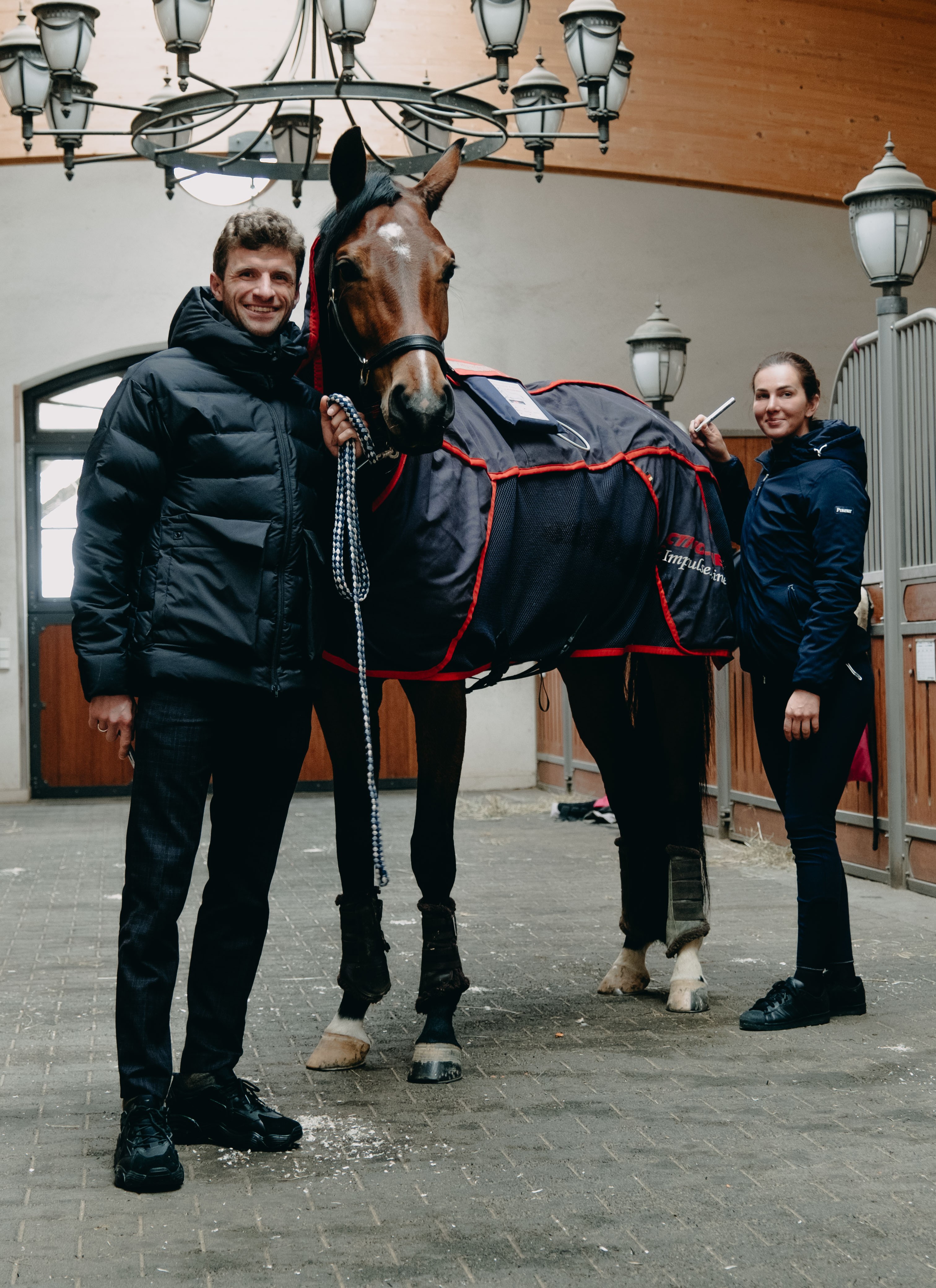 Familie Müller steht mit dem Pferd auf der Stallgasse